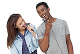 Young couple singing into microphones