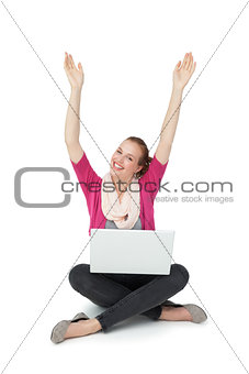 Hppy young woman with laptop raising hands