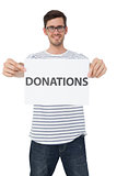 Portrait of a happy young man holding a donation note