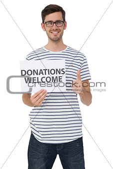 Man holding a donation welcome note while gesturing thumbs up