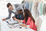Fashion designers discussing designs in studio