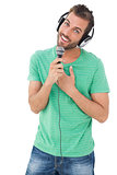 Portrait of a young man singing into microphone