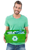 Portrait of a smiling man carrying recycle container