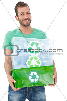 Portrait of a smiling young man carrying recycle containers