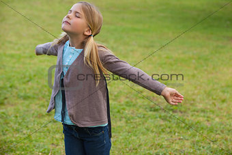 Girl with arms outstretched at park