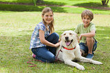 Portrait of kids playing with pet dog at park
