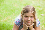 Close-up of a cute girl lying on grass at park