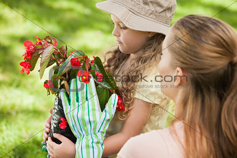 Mother and daughter with a flower pot at park