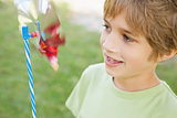 Boy looking at pinwheel in park