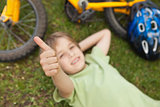 Relaxed boy gesturing thumbs up at park