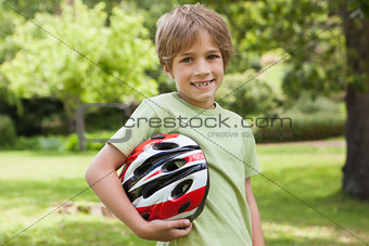 Smiling boy with bicycle helmet at park