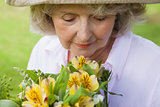 Mature woman smelling flowers at park