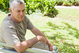 Thoughtful mature man sitting on park bench
