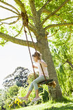 Young girl sitting on swing at park