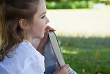 Close-up of young girl reading book in park