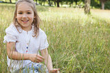 Smiling relaxed young girl sitting in field