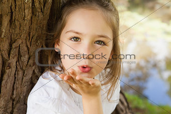 Close-up of a girl blowing a kiss at park