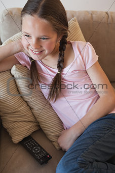 Smiling girl sitting on sofa in the living room