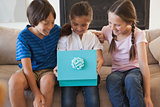 Happy kids with gift box in living room