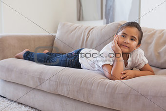 Relaxed young girl lying on sofa