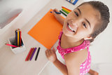 Young girl drawing on orange paper