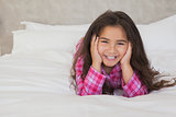 Portrait of a smiling girl lying in bed