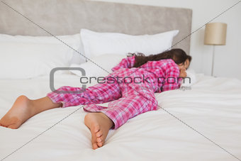Full length of girl sleeping in bed