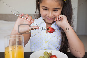 Close-up of a smiling girl eating fruits