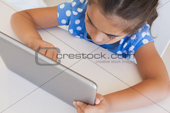 Close-up of a girl using digital tablet on table