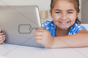 Close-up portrait of a girl using digital tablet