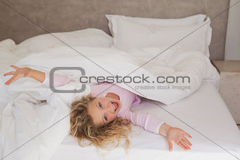 Portrait of a cheerful girl lying in bed