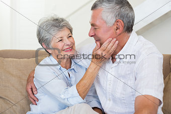 Affectionate retired couple sitting on the sofa