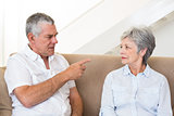 Senior couple sitting on couch having an argument