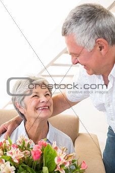 Senior man giving his partner a bouquet of flowers