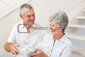 Senior man giving his happy partner a gift