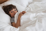 High angle portrait of a boy resting in bed