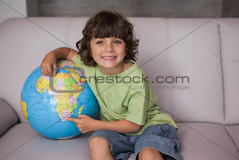Portrait of a happy kid with globe in living room
