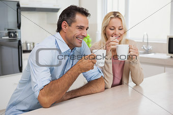 Smiling couple drinking coffee in kitchen