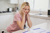 Unhappy woman with sitting in kitchen