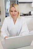 Portrait of a woman using laptop in kitchen