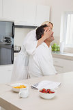 Woman covering man's eyes at breakfast table in kitchen