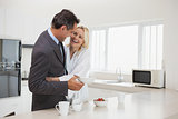 Woman embracing businessman in the kitchen