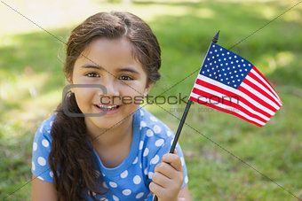 Young girl holding the American flag at park