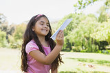 Girl playing with a paper plane at park