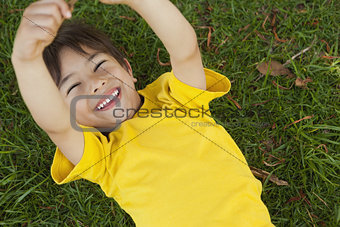 Young boy lying on grass at park