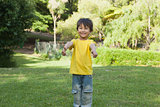 Young boy gesturing thumbs up in park