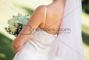 Mid section of a young beautiful bride with bouquet