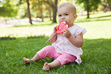 Cute baby with heart shaped lollipop at park