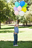 Young girl with colorful balloons at park