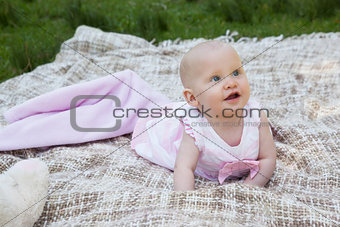 Cute baby lying on blanket at the park